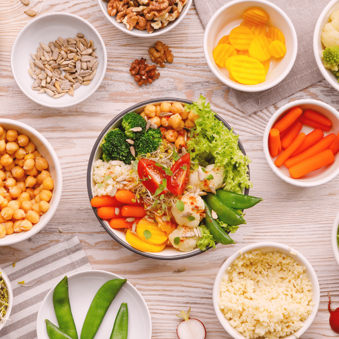 Un assortiment de légumes frais, de graines et de noix disposés sur une table en bois.